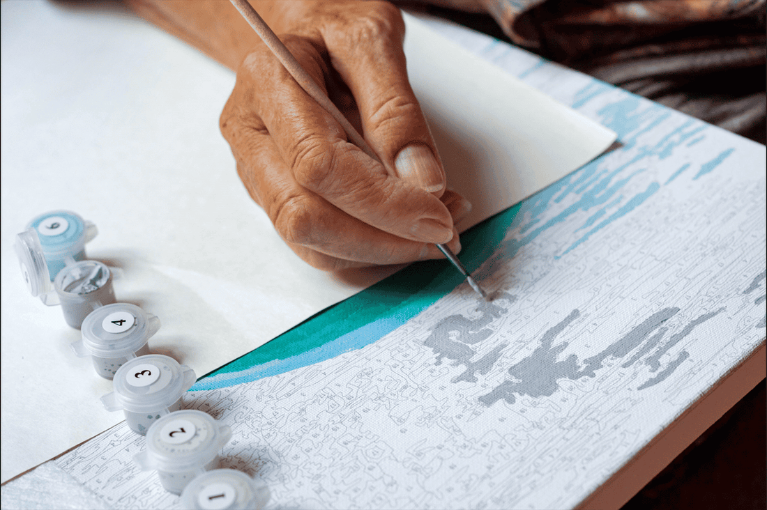 Hand painting a numbered area on a paint by numbers canvas